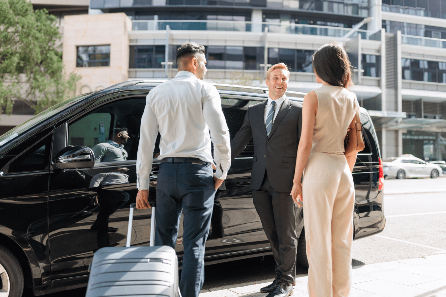 Friendly Car Australia chauffeur opening door for passengers Car Australia chauffeur smiling while holding car door for passengers